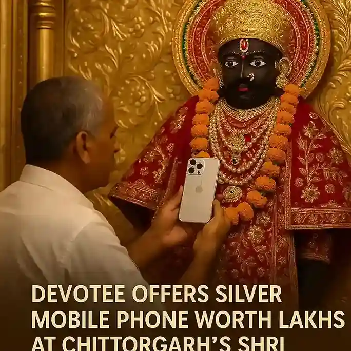 A close-up of a silver mobile phone being presented as an offering at the Shri Sanwaliya Temple.